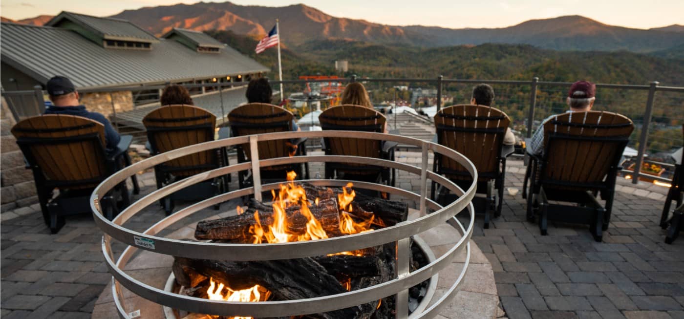 Guests enjoying the mountain views around a warm firepit.